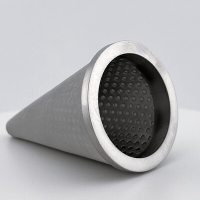 A metal mesh cone filter with a perforated end, placed on a white surface against a plain background.
