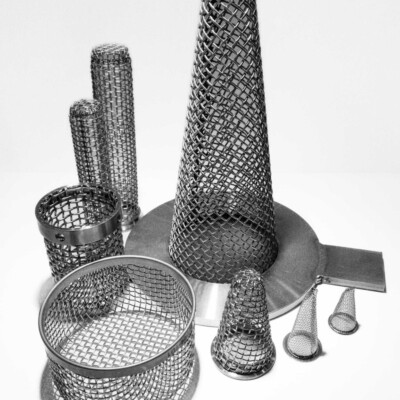 Metal mesh filters of various shapes and sizes are arranged on a flat surface against a plain background.